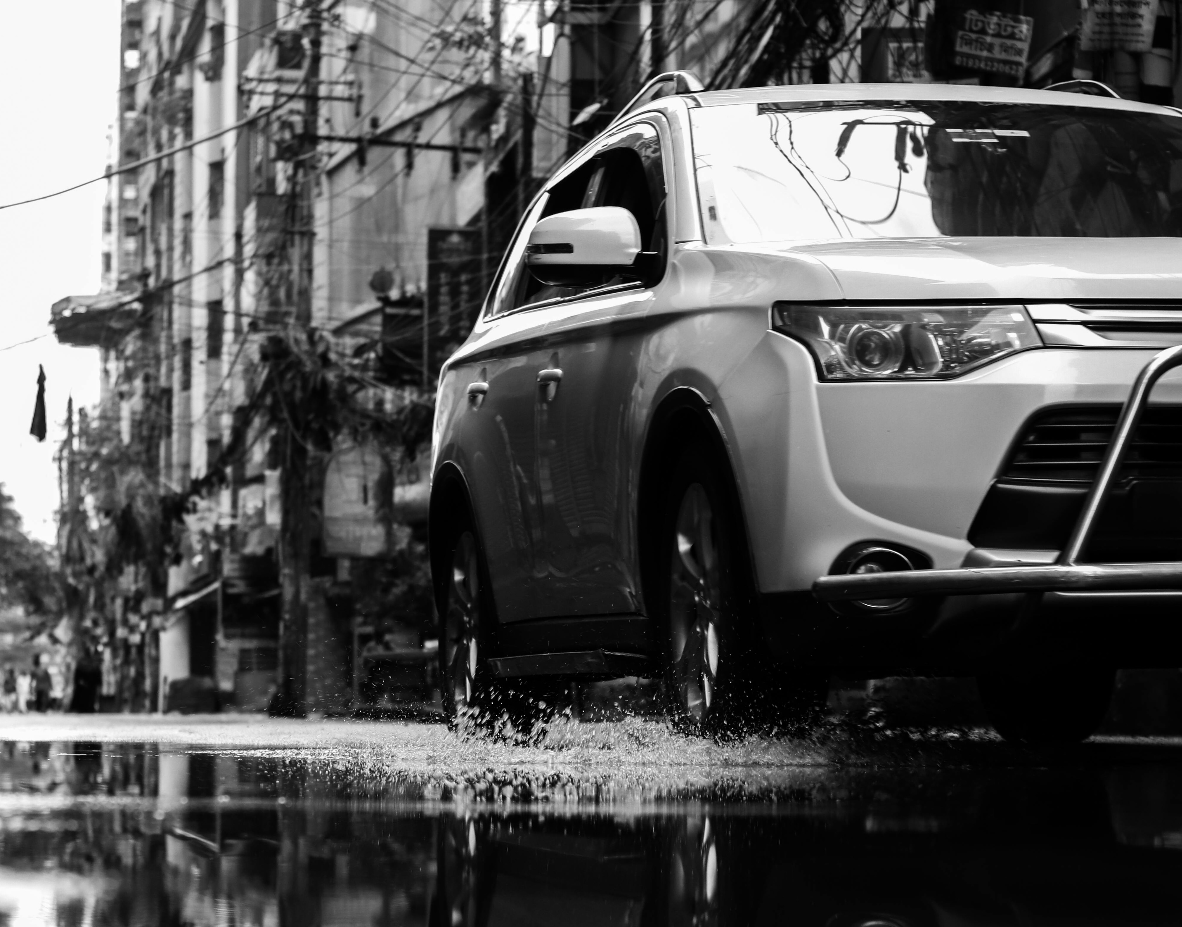 Car driving through puddle black and white