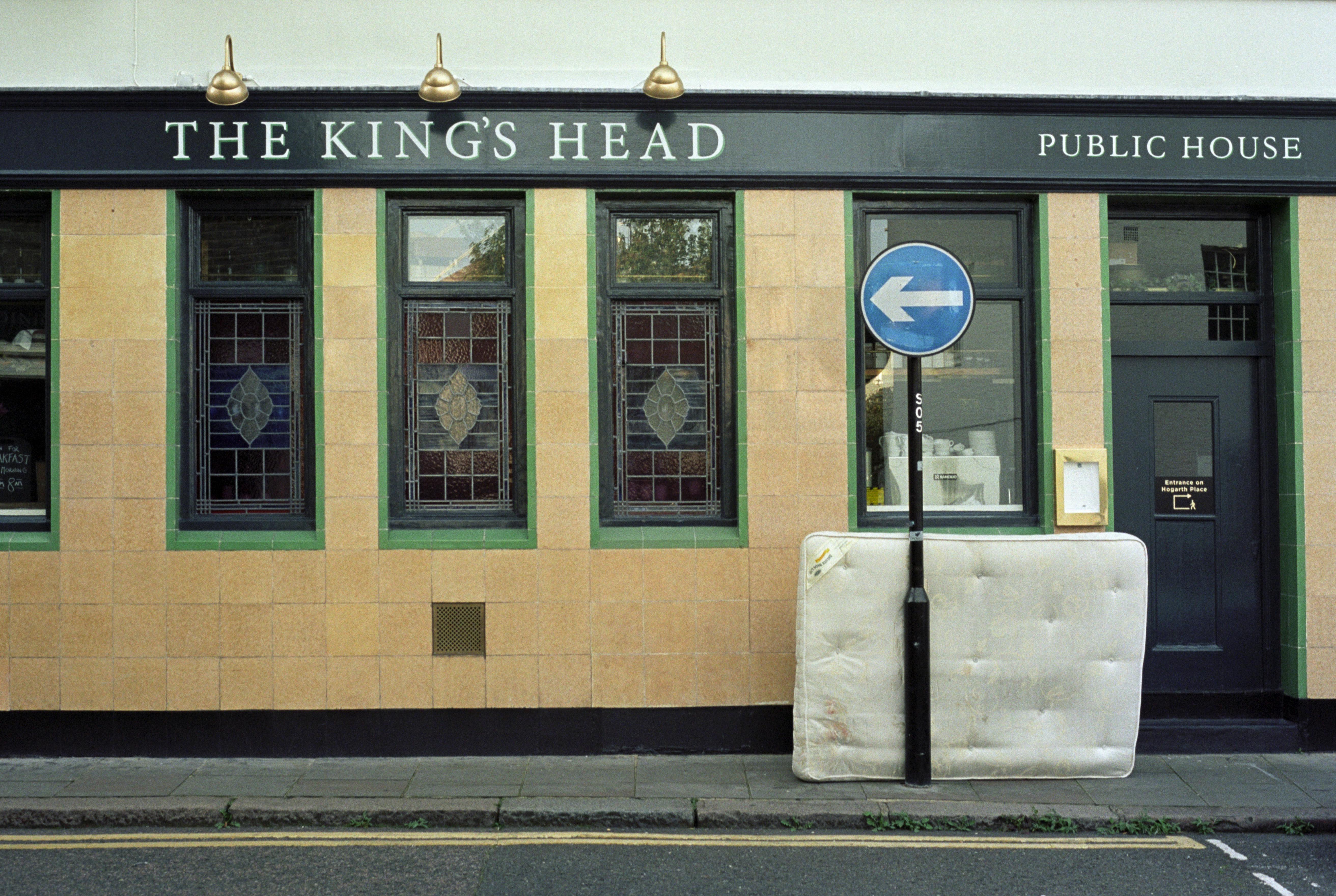White mattress dumped on pavement outside a pub called The King's Head